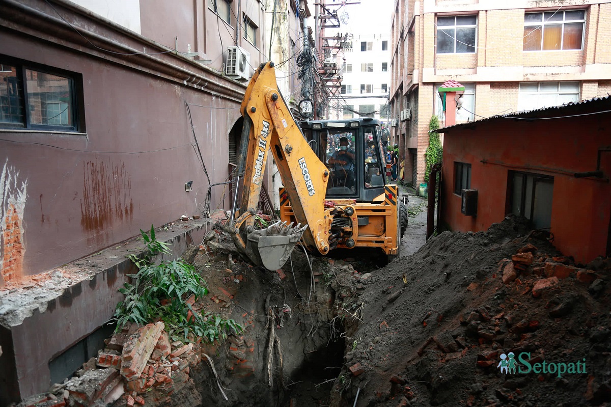 An excavator digging underground tunnel of Tukucha near Laxmi Bank at Hattisar, Kathmandu.